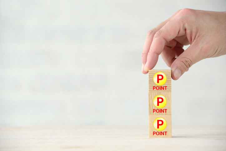 Wooden blocks with point letters, a hand is removing points from the top.