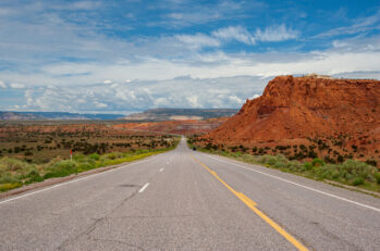 Red Rock formation on the side of the road on highway 84 in New Mexico near Ghost Ranch, Abiquiu with a blue cloudy textured sky.