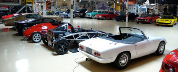 A garage with a bunch of fancy collector cars inside of it.