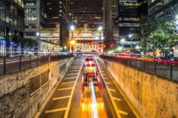 Long exposure image of a city street with blurred headlights from the cars.