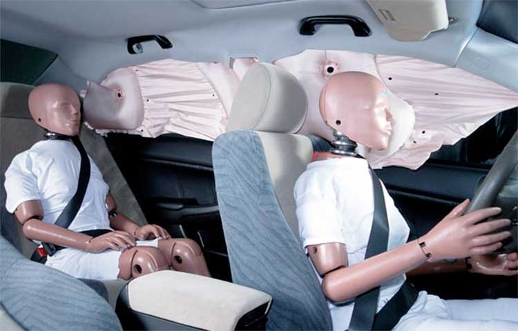 Dummies getting hit by air bags in a car safety test.